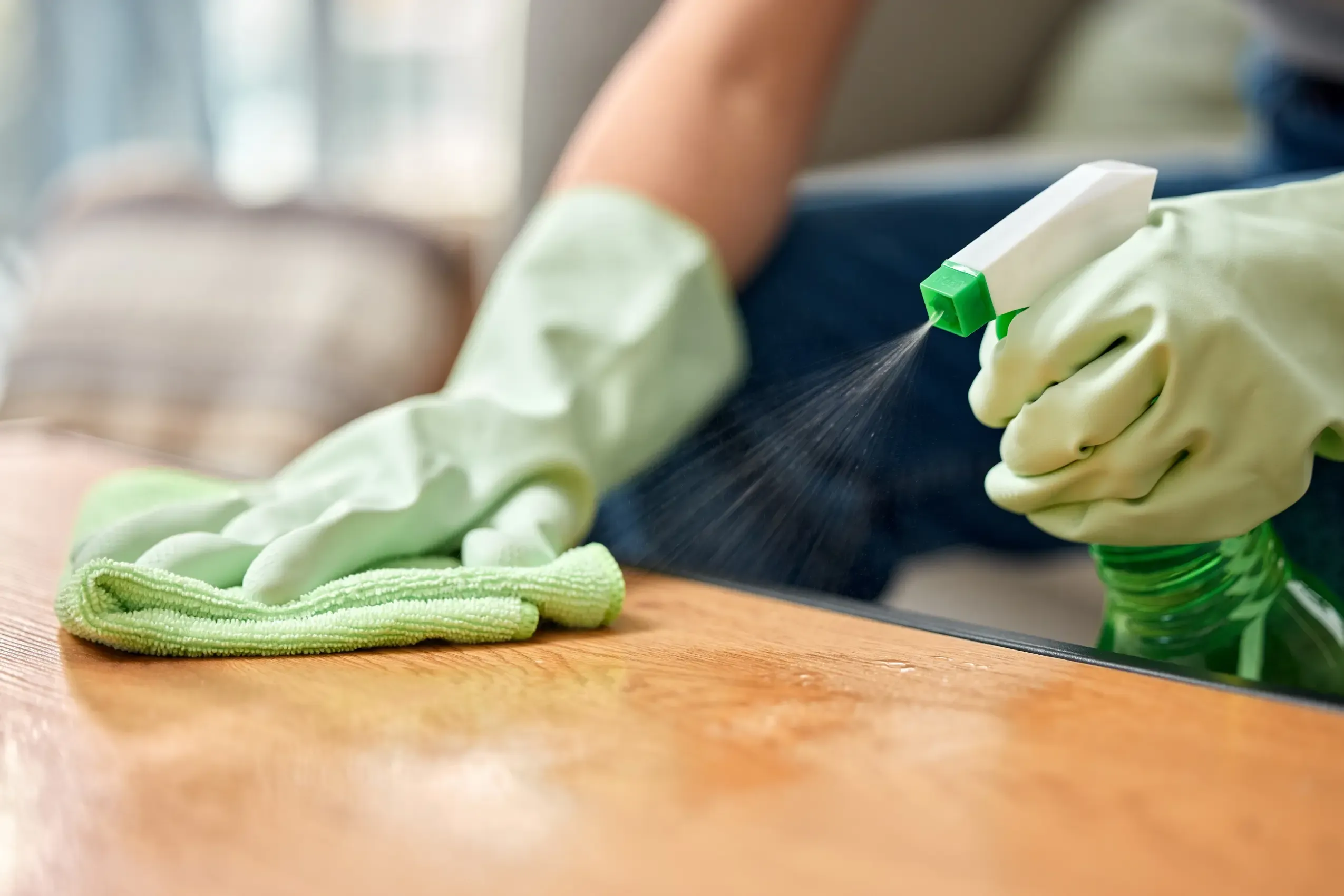 Green cleaning products being used on a hard surface inside a home