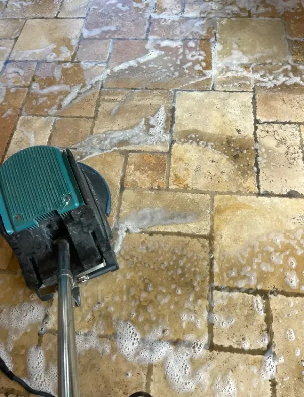A hard-surface spinner lifting soil out of stone tile grout lines